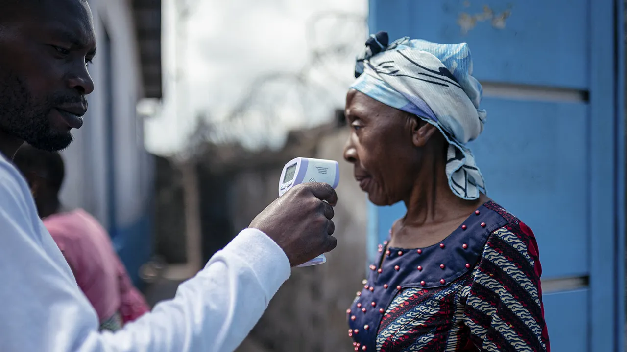 Healthcare worker takes a temperature reading at a clinic